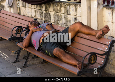 Sans-abri dormir paisiblement sur banc en bois Banque D'Images