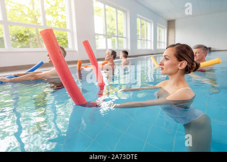 Les patients au cours de la remobilisation dans un centre de santé faisant d'aquagym Banque D'Images