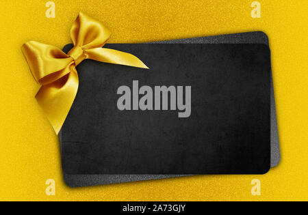 Carte cadeau noir avec golden ribbon bow, concept vendredi noir Banque D'Images