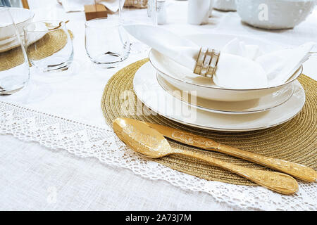 Réglage de la table de luxe - golden couverts et des assiettes avec serviette sur nappe blanche en close-up Banque D'Images