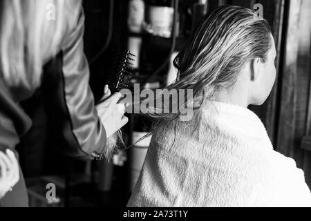 Le brossage des cheveux humides coiffure professionnel de belle jeune femme blonde avant teinture cheveux. Produits de soins capillaires, santé et beauté. Photo gros plan de Banque D'Images