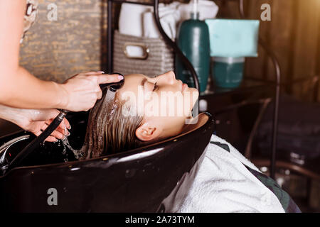 Belle femme blonde coiffure cheveux lavages des clients dans un salon de coiffure. Redressage de la kératine, la teinture, de soins et de procédures spa. Banque D'Images