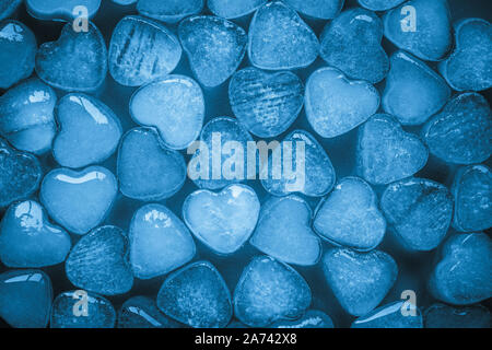 Coeur de glace sur fond bleu. Creative design minimaliste. Carte romantique avec coeur cool congelé. Image abstrait dans un style moderne. Texture lumineuse, Banque D'Images