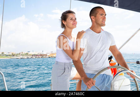 Jeune couple aimant debout à la mer roue yacht voyage le long des côtes de Barcelone le jour ensoleillé Banque D'Images