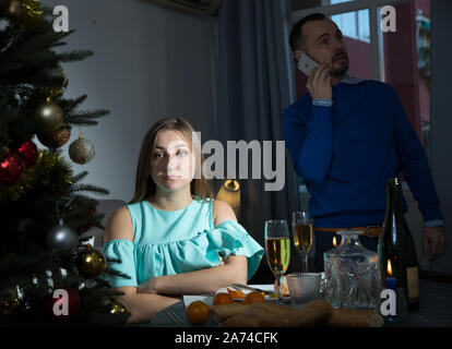 Jeune couple offensé des problèmes en relation, ignorant les uns les autres dans la nuit de Noël Banque D'Images
