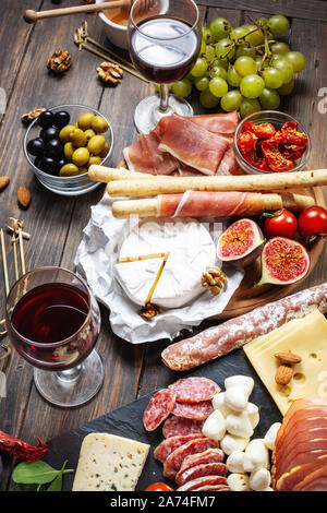 Antipasti italiens avec prosciutto, jambon, fromage, olives et grissini batonnets sur fond de bois rustique Banque D'Images