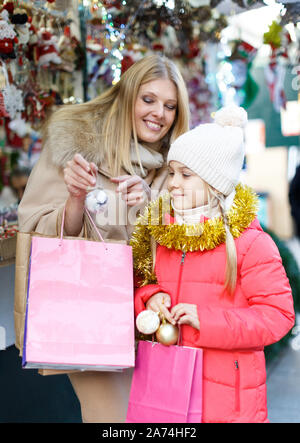 Cute Smiling preteen girl s'amusant sur Noël avec la mère, la sélection de décoration pour la maison Banque D'Images