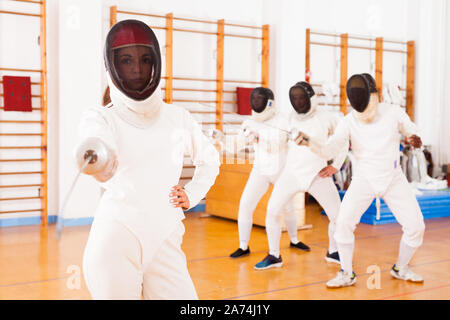 Portrait de jeune femme sportive en masque de papier d'aluminium à un entraînement d'escrime Banque D'Images