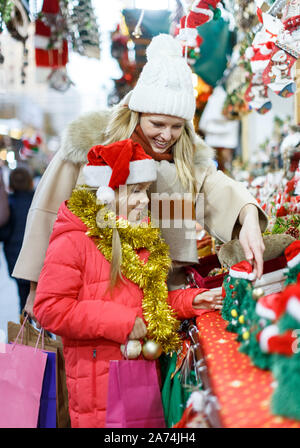 Cute Smiling preteen girl s'amusant sur Noël avec la mère, la sélection de décoration pour la maison Banque D'Images