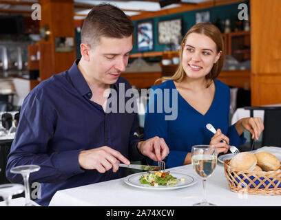 Couple heureux sur la salade et de l'alimentation date drinking white wine in restaurant Banque D'Images