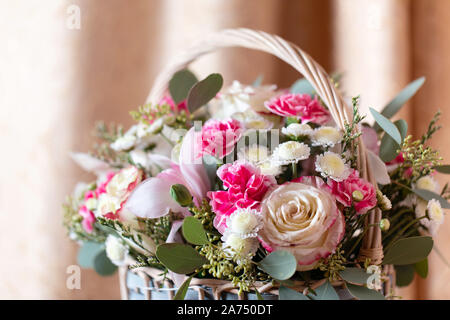 Close up of pink flower arrangement. Rose, Dianthus, Alstroemeria, chrysanthème, Eucalyptus. Bouquet de fleurs de printemps dans le panier. Banque D'Images