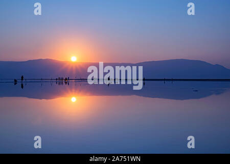 Un groupe de photographes à prendre des photos de lever de soleil sur la rive de la Mer Morte. Israël Banque D'Images