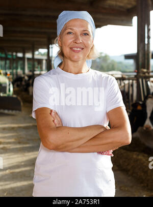 Senior female farmer posing in étable à dairy farm Banque D'Images