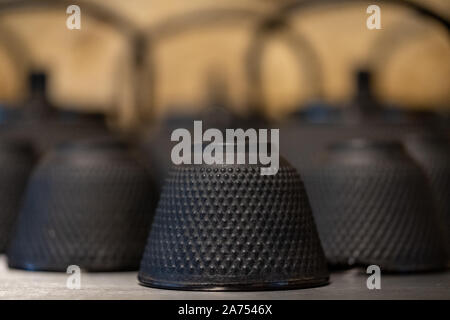 Close up of black fonte texturée théières de style asiatique avec des poignées et des tasses. Banque D'Images