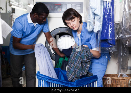 L'accent africain avec sa femme sous-vêtements sales de tri et mettre en machine à laver de la blanchisserie Banque D'Images