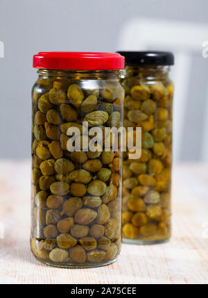 Câpres au vinaigre dans un bocal en verre sur la table en bois Banque D'Images