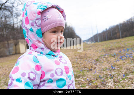 Girl et quelques fleurs snowdrop bleu derrière Banque D'Images