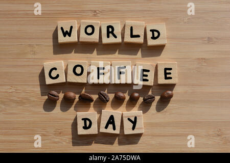 Journée mondiale du café. Mots en lettres de l'alphabet en bois 3d avec les grains de café sur un fond de bois de bambou Banque D'Images