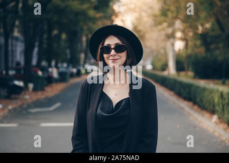 Automne 2019 parfaite tenue. mode la mode européenne blogger portant haut satin de soie noire, blazer, lunettes carrés et une fedora hat. street style po Banque D'Images