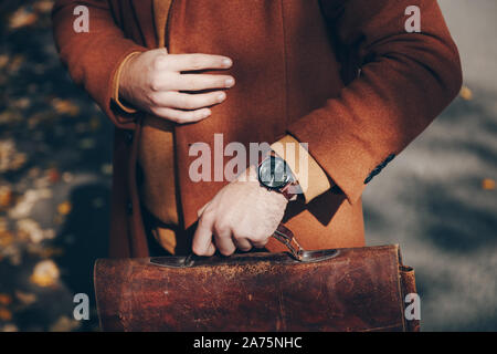 Street style 2019 automne automne fashion, Close up detail de la mode des hommes. accessoire homme portant une élégante montre-bracelet et la tenue d'un cuir vintage t0 Banque D'Images