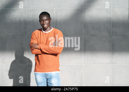 Portrait de jeune homme africain Crossing Arms and Smiling Banque D'Images
