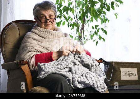Close-up Portrait of Senior Woman Knitting avec de la laine, fil de laine tricotées mains grands-mères. L'artisanat est Hobby de vieille femme. Senior Lady, Happy Granny Knitte Banque D'Images