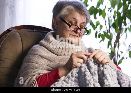 Close-up Portrait of Senior Woman Knitting avec de la laine, fil de laine tricotées mains grands-mères. L'artisanat est Hobby de vieille femme. Senior Lady, Happy Granny Knitte Banque D'Images