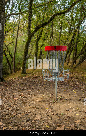 Dans les bois sur le parcours pédestre est un disque vide panier golf # 5 avec des arbres en arrière-plan sur une journée ensoleillée à l'automne Banque D'Images