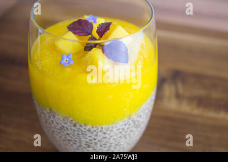 La photographie culinaire d'un chia pudding au lait de coco et mangue puré. Banque D'Images