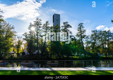 Allemagne, lac magnifique avec des îles de fleurs dans un parc public de la ville de schorndorf feuersee entouré d'arbres à côté d'un clocher de l'église dans la lumière magique Banque D'Images