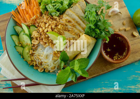 La photographie culinaire d'une salade de nouilles vietnamiennes chay bun rouleaux de printemps avec du tofu frit et des légumes. Banque D'Images