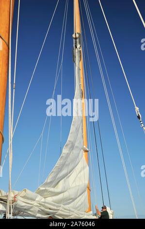 White sails soulevées, remplissage avec du vent, le schooner America 2.0 qui sillonnent les eaux turquoise au coucher de naviguer au large de Key West, Florida Keys, Floride, USA Banque D'Images