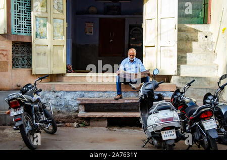 Jodhpur, Inde - 28 Février, 2018 : Indian man reading a newspaper in ville bleue Jodhpur. Banque D'Images