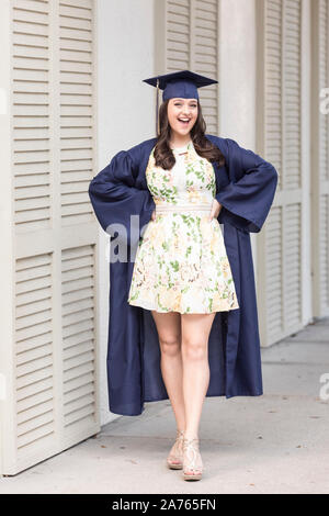 Sassy girl smiling senior pose à cap and gown sur coin de rue Banque D'Images