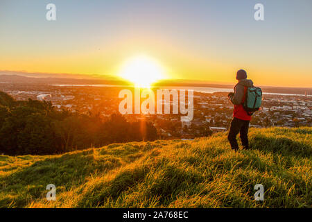 Man staring out vers la ville au coucher du soleil à Auckland en Nouvelle-Zélande. Banque D'Images