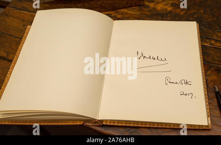 Le Prince de Galles en tant que président du National Trust sur une visite à Chartwell House, ancienne maison de campagne de Sir Winston Churchill, qui a connu une restauration. Le Prince Charles signature dans le livre d'or. Banque D'Images