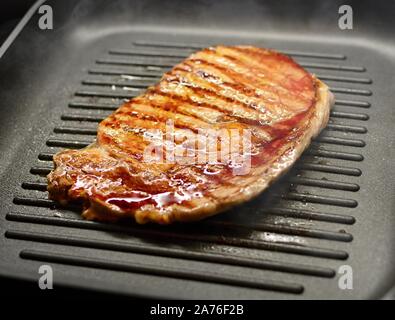 Pavé de boeuf frais grillé à la vapeur et de la fumée sur l'Iron Grill Pan. Banque D'Images