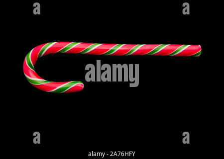 Noël traditionnel caramel candy cane isolé sur un fond noir. Carte de vœux des fêtes des vacances d'hiver avec l'exemplaire de l'espace pour le texte. Télévision Noël Banque D'Images