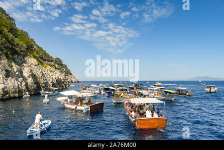 Île de Capri, ITALIE - AOÛT 2019 : les gens dans de petites embarcations attendent de voir la "Grotta Azzurra" ou "Blue Grotto' cave sur la côte de Capri Banque D'Images