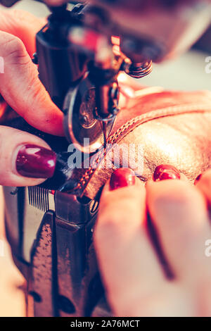 Cordonnier couture femme mains une partie de la chaussure dans une usine de chaussures Banque D'Images