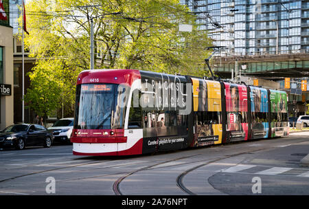 Toronto, Canada - 0609 2019 : un nouveau bombardier-faite TTC streetcar avec bannières publicitaires sur ses côtés se déplaçant le long de l'avenue Spadina à Toronto. Toronto Banque D'Images