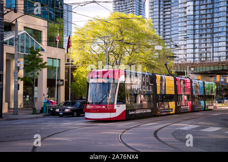 Toronto, Canada - 0609 2019 : un nouveau bombardier-faite TTC streetcar avec bannières publicitaires sur ses côtés se déplaçant le long de l'avenue Spadina à Toronto. Toronto Banque D'Images