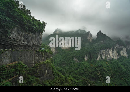 Bus avec les touristes de prendre la route jusqu'à la route sinueuse de 99 se tourne vers le haut de la montagne Tianmen, parc national de Zhangjiajie, Hunan, Chine Banque D'Images