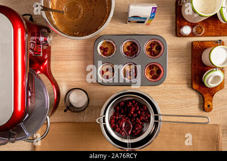 Muffins cerises aigres en allant au four avec les tasses de papier Banque D'Images