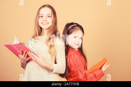 Faire de la recherche. des cahiers d'écriture. Retour à l'école. Les élèves de lire un livre. Projet d'école. L'amitié et de solidarité entre elles. Les petites filles avec note books. Heureux petits enfants prêts pour l'école leçon. Banque D'Images