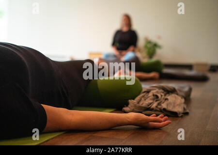 Selective focus photo d'une caméra filmant un enseignant de yoga professionnel expliquant des postes dans une session de groupe de yoga Banque D'Images