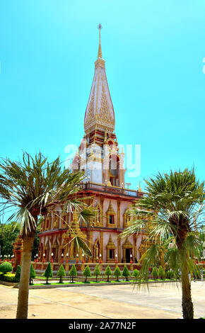 Une vue sur le chedi entre deux palmiers au Temple de Chalong Phuket Thaïlande Banque D'Images