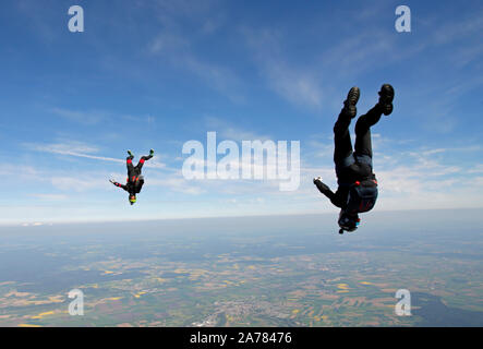 Cette équipe est la tête en bas, le parachutiste formation ensemble l'inface tracking autour de l'autre. C'est amusement pour les deux plongeurs et bientôt ils tiendront des poignées. Banque D'Images