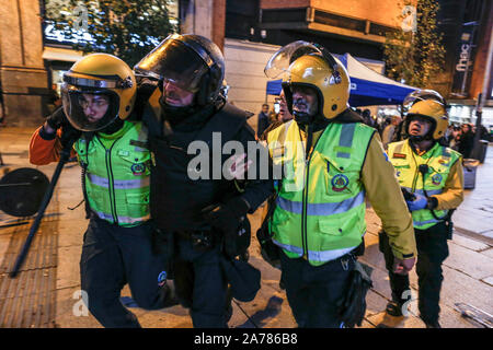 Un policier blessé pris en charge par les ambulanciers au cours des affrontements. Des centaines de manifestants d'extrême gauche se sont heurtés à la police après une manifestation pacifique contre la sentence de la Cour suprême de la politique catalane et de militants. Ils étaient plus de 10 détentions et certains fonctionnaires de police ont été blessés. Dans une tentative de recréer les violentes émeutes de Barcelone, les manifestants se sont installés des barricades dans quelques rues du centre-ville. Banque D'Images