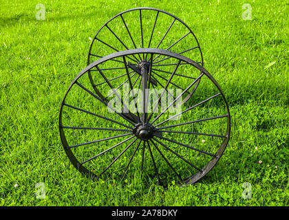 Black metal Vintage sur l'axe des roues sur l'herbe verte au jour d'été ensoleillé, vue latérale Banque D'Images